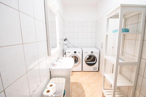 a white laundry room with a washer and dryer at Umag seafront seaview center apartments old town 1,2,3,4 by Rentistra in Umag