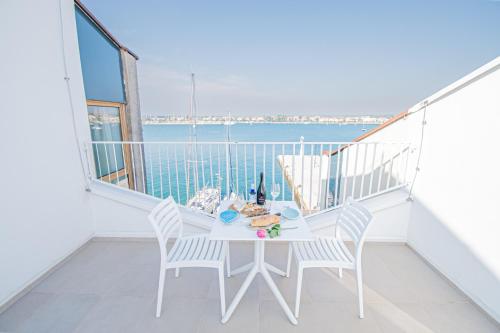 einen weißen Balkon mit einem Tisch, Stühlen und Meerblick in der Unterkunft umag seafront seaview center apartment old town rentistra 3 in Umag