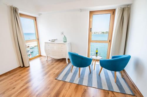 ein Wohnzimmer mit 2 blauen Stühlen und einem Tisch in der Unterkunft umag seafront seaview center apartment old town rentistra 3 in Umag