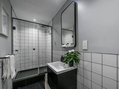 a white bathroom with a sink and a mirror at Luxury City Living - 1 Bedroom with balcony in Cape Town
