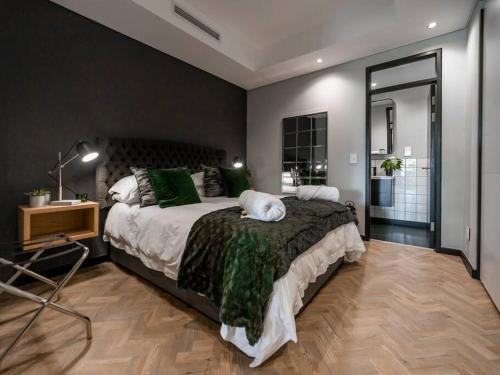 a bedroom with a large bed with a cat laying on it at Luxury City Living - 1 Bedroom with balcony in Cape Town