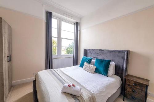 a bedroom with a bed with blue pillows and a window at Modern Cambridge Park with FREE PARKING by Prescott Apartments in Bristol