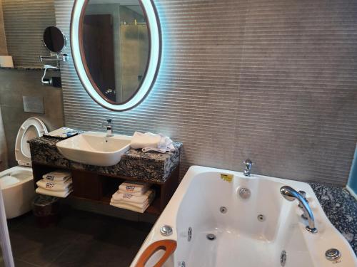 a bathroom with a sink and a tub and a mirror at Hotel Windy Terrace in Cox's Bazar