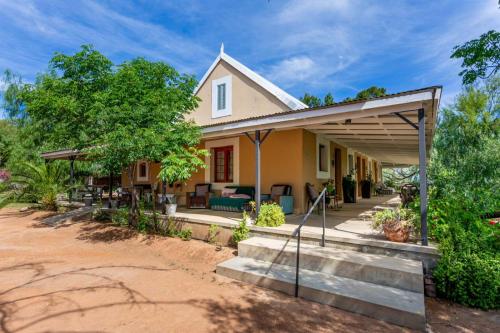 uma casa com um alpendre e uma entrada em Bella de Karoo em Calitzdorp