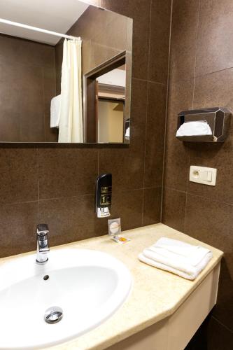 a bathroom with a sink and a mirror at Hotel Max Inn in Bratislava