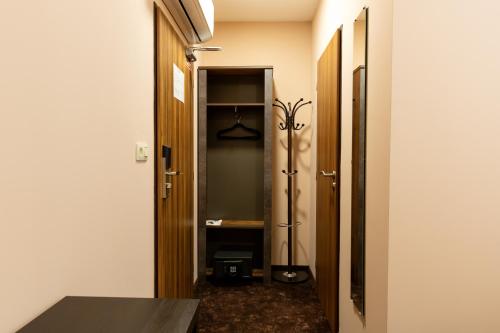 a hallway with a walk in closet and a mirror at Hotel Max Inn in Bratislava