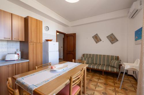 a small kitchen with a table and a couch at Conchiglia al Mare in Trappeto