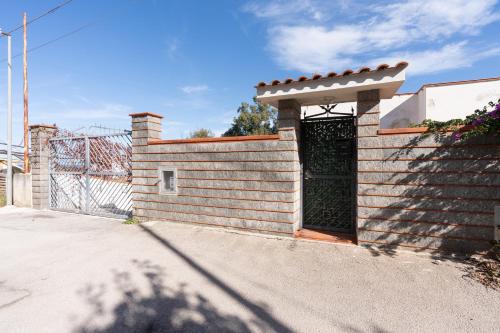 a brick wall with a gate on a street at Conchiglia al Mare in Trappeto