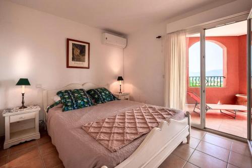een slaapkamer met een groot bed en een balkon bij Esprit du Sud Mascolo in Roquebrune-sur-Argens
