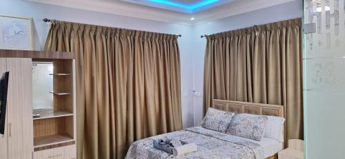 sypialnia z łóżkiem i oknem z zasłonami w obiekcie Cozy Luxury Hideouts in North Ridge, Accra, 1BDRM - 2BDRM, 15 mins from Airport w Akrze