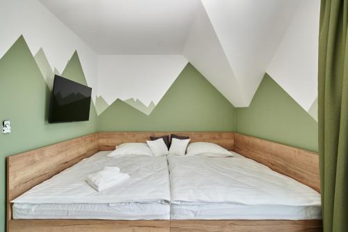 a bedroom with a bed with mountains on the wall at Tatra Green in Veľká Lomnica
