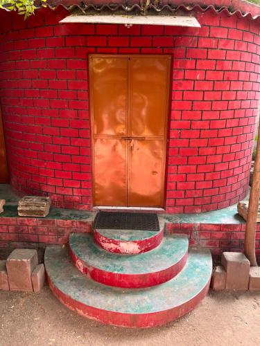 a red brick building with a red door on it at Sharad Baug homestay in Bhuj