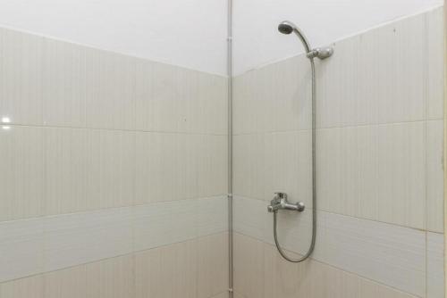 a shower with a shower head in a bathroom at RedDoorz @ Pantai Panjang Bengkulu in Pekansaptu