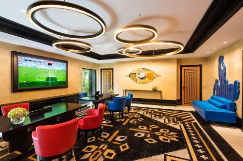 a living room with a television and a table and chairs at Dinamo Hotel Baku in Baku