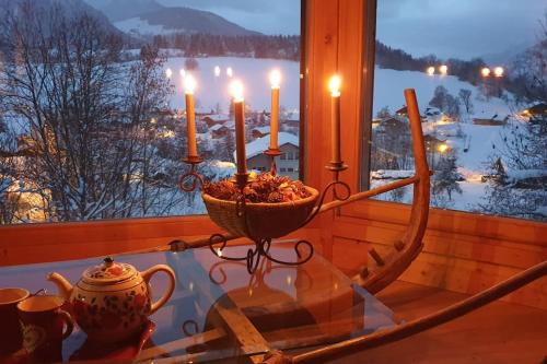 a glass table with candles on top of a window at Très belle vue pour un chalet de 200 m2 in Arâches-la-Frasse