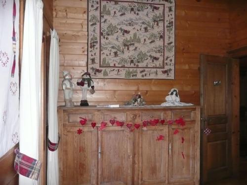 a room with a wooden cabinet with a tapestry on the wall at Très belle vue pour un chalet de 200 m2 in Arâches-la-Frasse