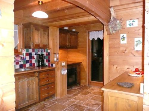 cocina con armarios de madera y encimera en Très belle vue pour un chalet de 200 m2, en Arâches-la-Frasse
