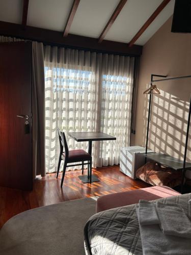 a bedroom with a table and a chair and a bed at Quinta do Esquilo - Hotel Rural in Rendufe