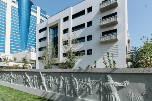 a mural on a wall in front of a building at Dinamo Hotel Baku in Baku