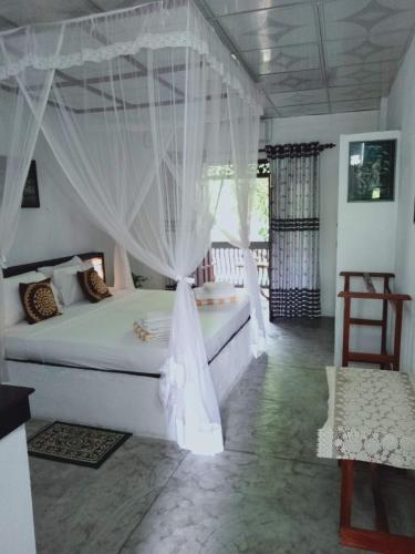 a bedroom with a bed with a mosquito net at SanjeeHome & Lanka Ayurveda, Bentota in Bentota
