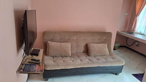 - un canapé avec deux oreillers dans le salon dans l'établissement Istana Bromo Resort, à Bromo