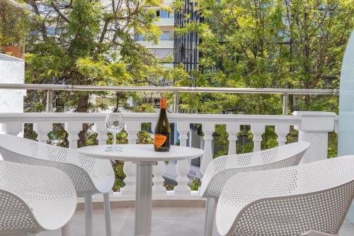 a white table and chairs on a balcony with a bottle of wine at Epavli Grace Hotel in Chania Town