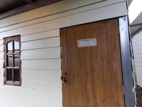 a door of a house with a sign on it at Panakluea at Kokuang Homestay in Ban Na Lae