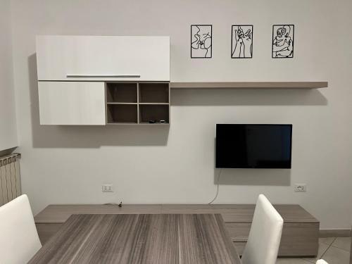 a kitchen with white cabinets and a flat screen tv at Sottomarina Beach Life in Sottomarina
