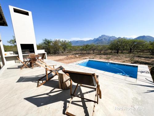 a patio with two chairs and a swimming pool at 24 Degrees South Country Estate in Hoedspruit