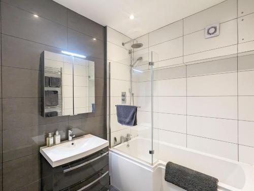 a white bathroom with a sink and a shower at Thomond House, Midhurst in Midhurst