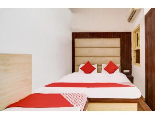 a bedroom with a large bed with red pillows at HOTEL MIDTOWN INN, Singrauli in Singrauli