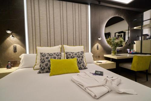 a bedroom with a large white bed with a yellow pillow at Hotel Regina in Madrid