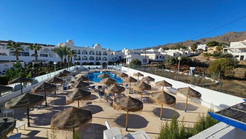 a group of chairs and umbrellas in front of a resort at Hotel El Puntazo I in Mojácar