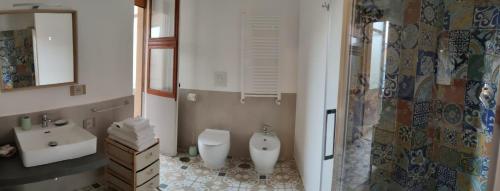 a bathroom with two sinks and a toilet and a shower at Edahouse in Salerno