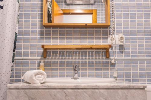 ein blau gefliestes Bad mit einem Waschbecken und einem Spiegel in der Unterkunft Terralta in Granada
