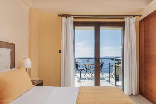 a bedroom with a bed and a view of the ocean at Costa Smeralda in Sivota