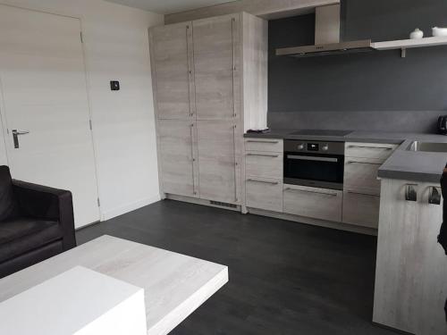 a kitchen with white cabinets and a stove top oven at Zomerhuisje 18K - 1 km van het strand in Wijk aan Zee