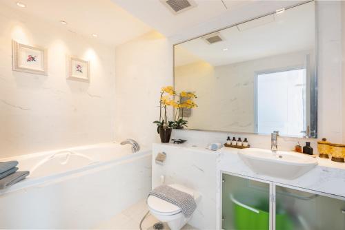 a bathroom with a sink and a tub and a mirror at Sky Villas Apartments in Bangkok
