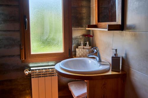 baño con lavabo y ventana en Alojamiento Rural Fuente del Arca (Prádena del Rincón) en Prádena del Rincón