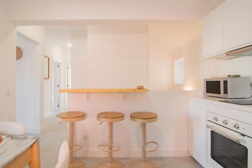 a kitchen with two stools and a microwave at Chalet Maria da Assunção in Estoril