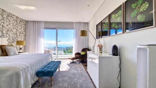 a bedroom with a bed and a large window at 24, The Townhouse by LovelyStay in Funchal