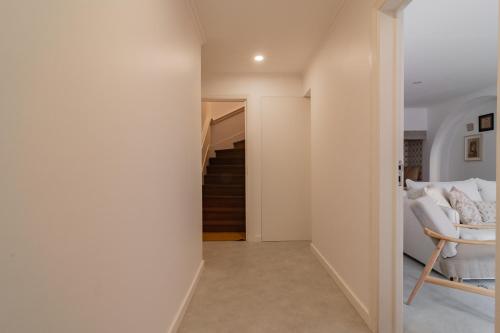a hallway of a house with a staircase and a chair at Chalet Maria da Assunção in Estoril