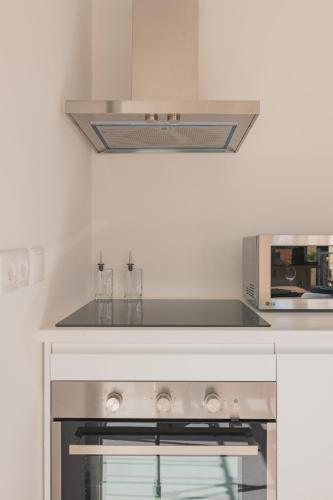 a kitchen with a stove and a microwave at Chalet Maria da Assunção in Estoril