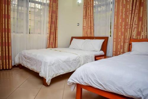 a bedroom with two beds and a window at The Luxurious Farm House in Kiambu