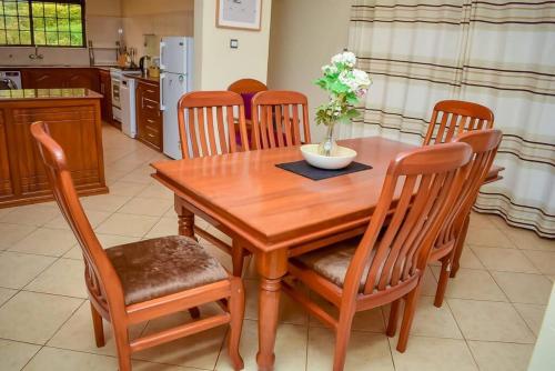 a wooden table and chairs in a kitchen at The Luxurious Farm House in Kiambu
