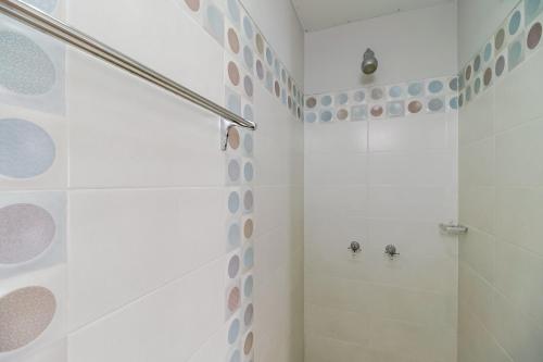 a white bathroom with a shower and a toilet at RedDoorz near Jam Gadang Syariah Bukit Tinggi in Bukittinggi