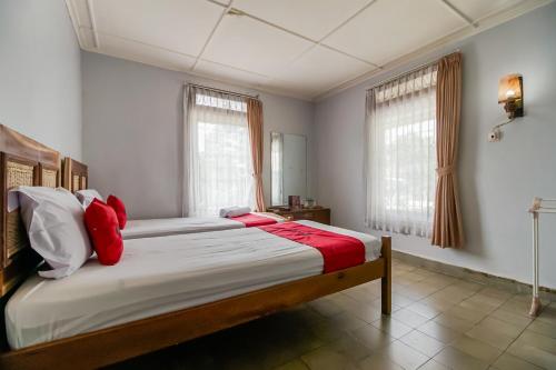 a bedroom with a large bed with red pillows at RedDoorz near Jam Gadang Syariah Bukit Tinggi in Bukittinggi