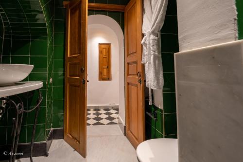 a bathroom with a sink and a toilet and green tiles at Riad Dar Chama in Chefchaouen