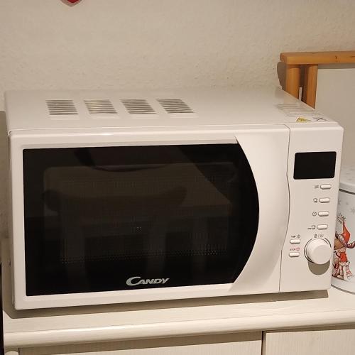 a white microwave oven sitting on top of a counter at FeWo mit tollem Ausblick auf der Schwäbischen Alb. in Wehingen