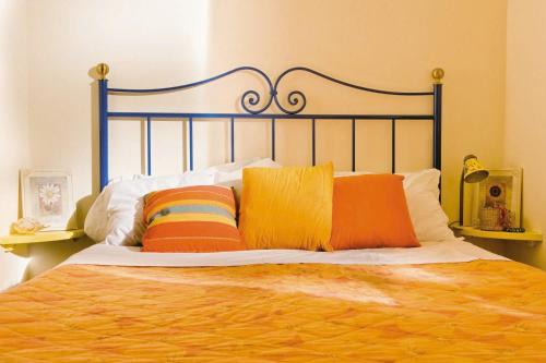 a bed with two colorful pillows on it at Camping Village Le Capanne in Marina di Bibbona
